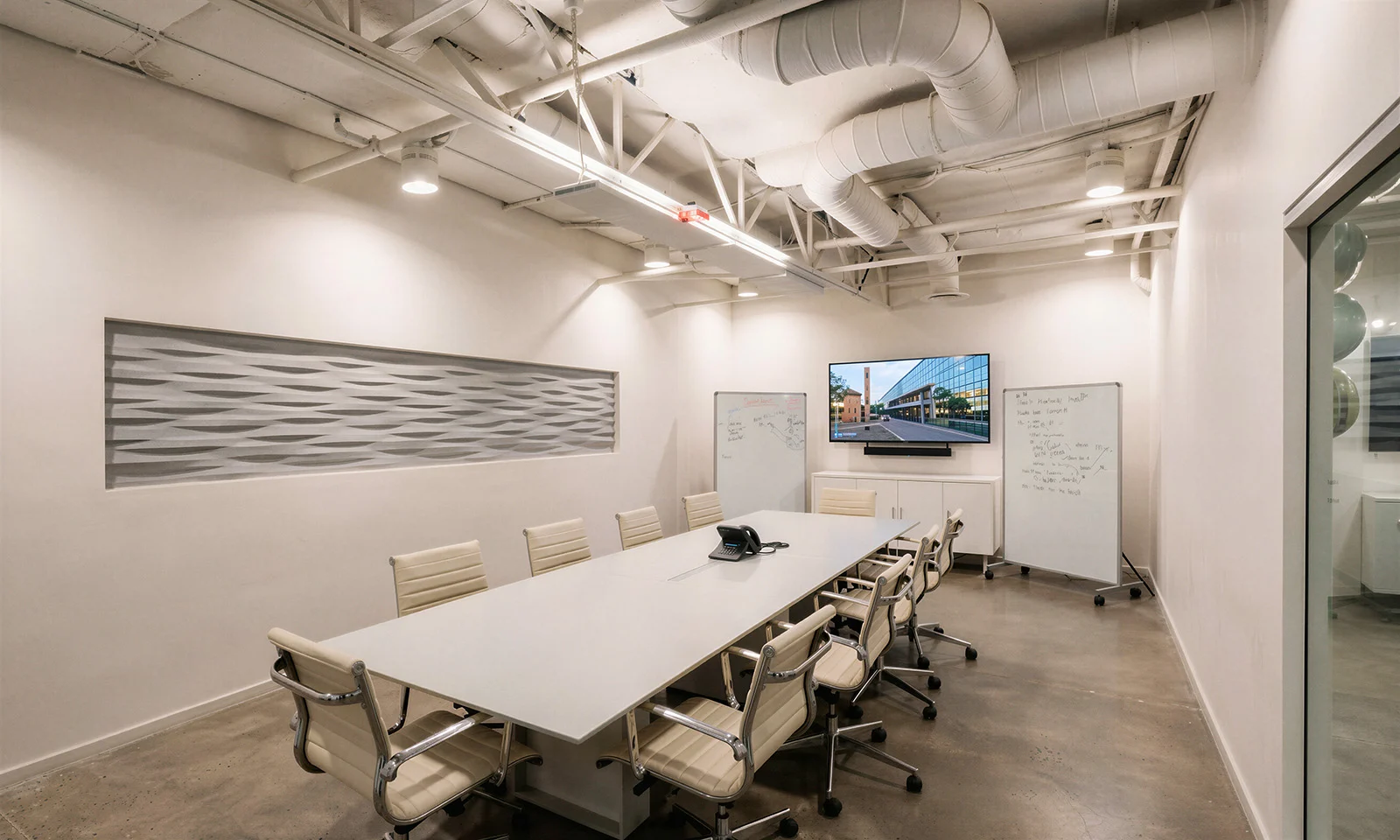 Conference room with glass wall and exposed ductwork